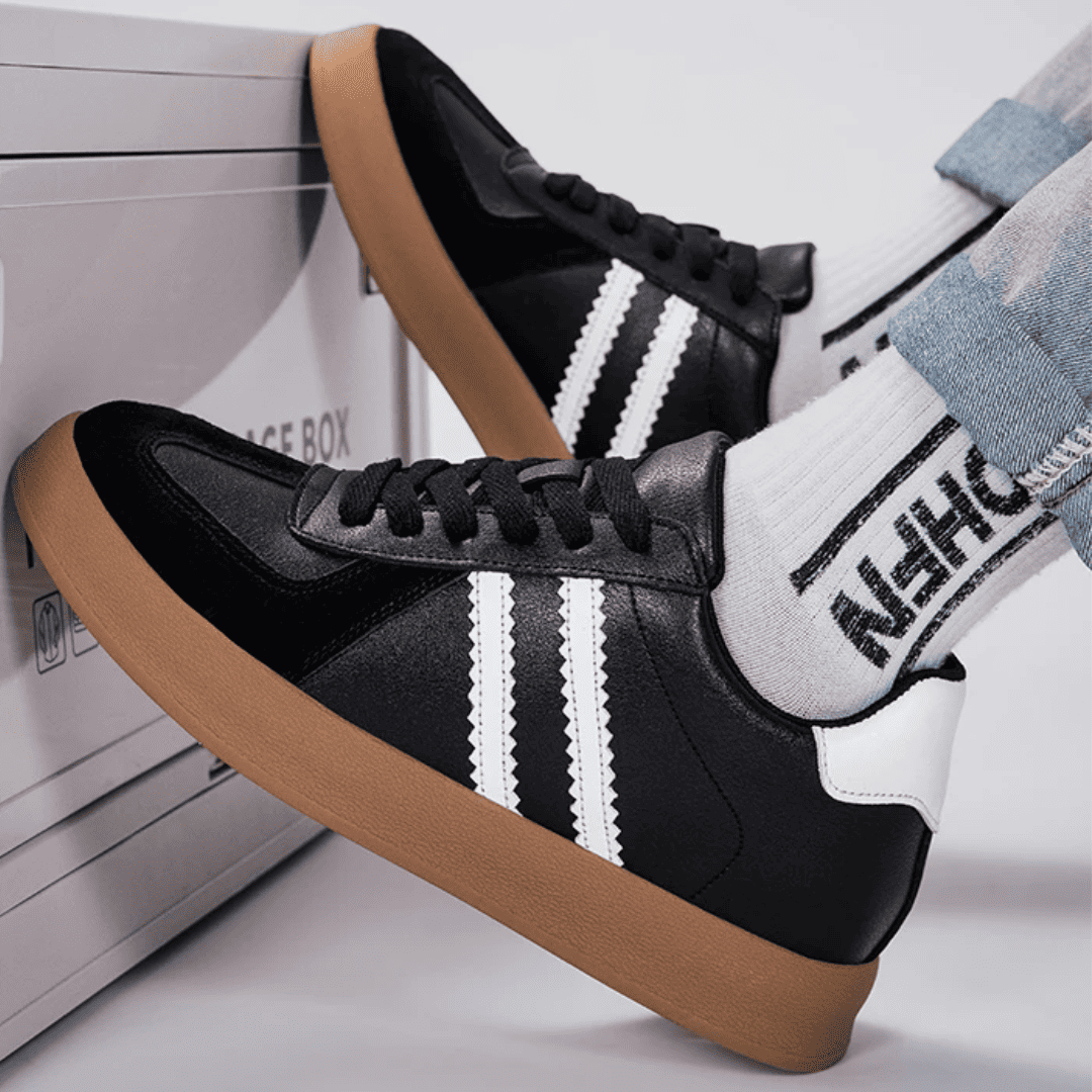 FORCIANO SABER black height increasing sneakers with white stripes, gum soles and split leather uppers shown worn in a close-up casual lifestyle scene.
