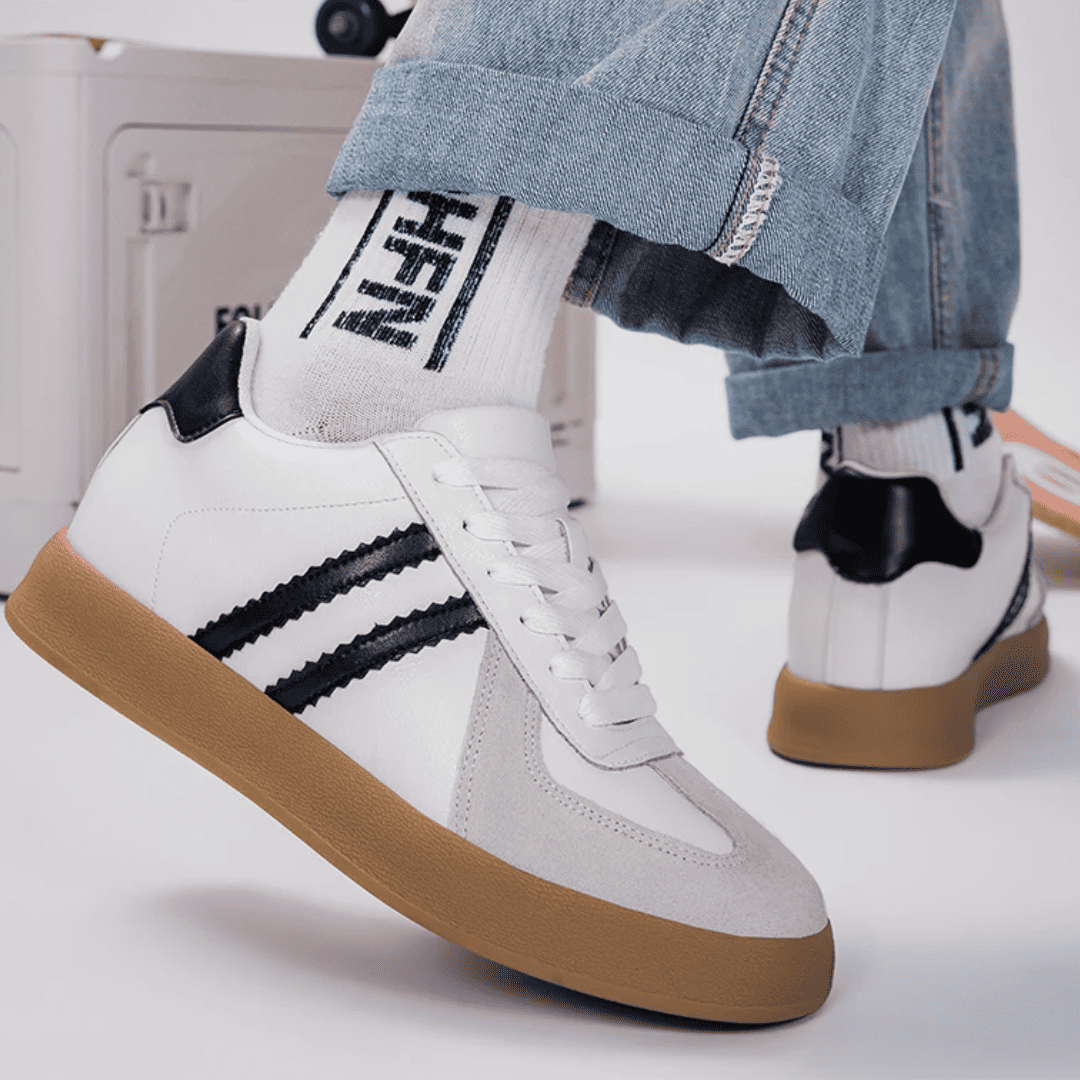 FORCIANO SABER white height increasing sneakers with black stripes and split leather uppers worn with cuffed jeans in a casual lifestyle view.