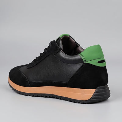 FORCIANO SALVATORE black height increasing sneakers with cow suede upper, green heel accent and tan midsole shown from a rear three-quarter angle.