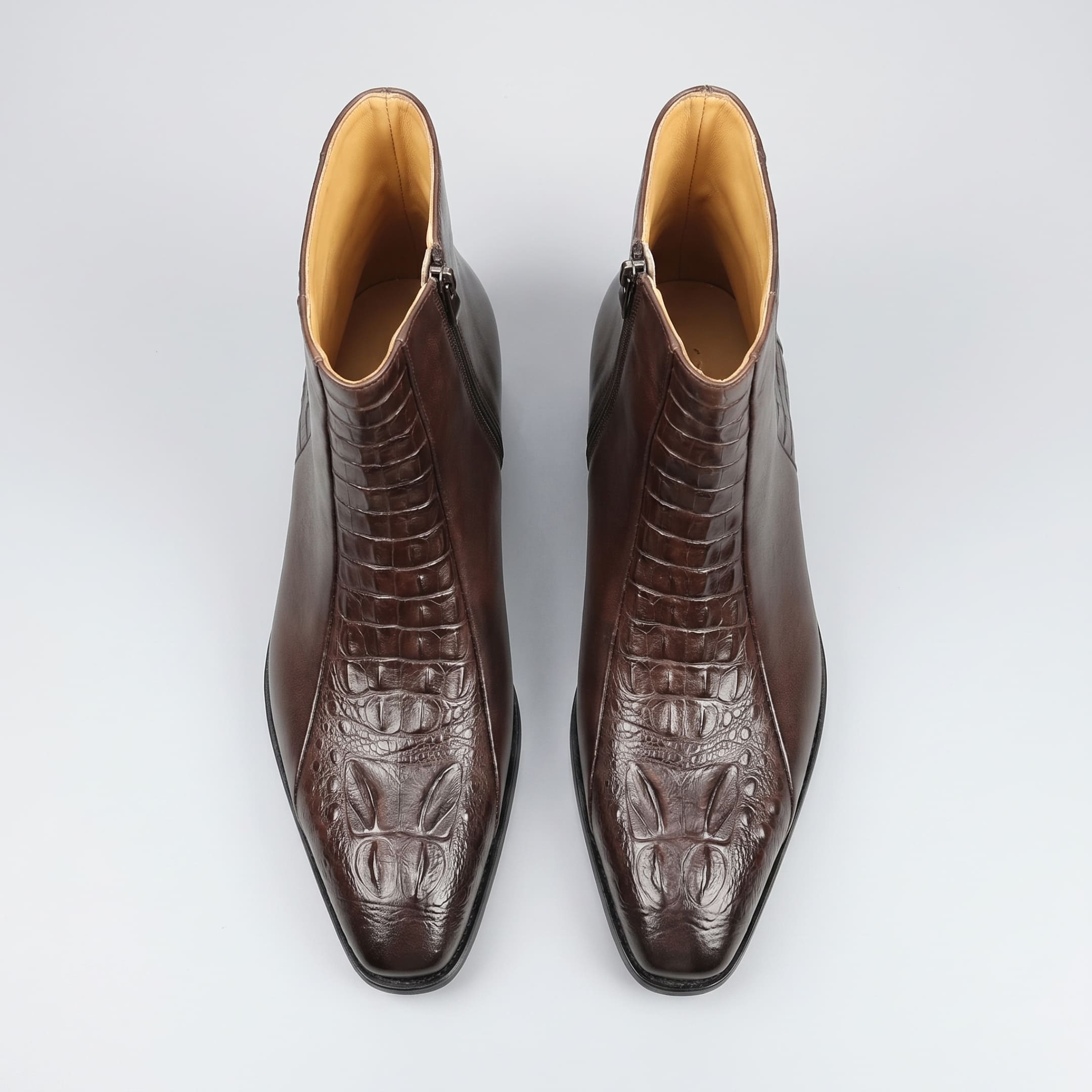 FORCIANO SAVIERO coffee elevator boots with genuine leather uppers shown as a pair from above, highlighting crocodile-engraved fronts and ankle openings.