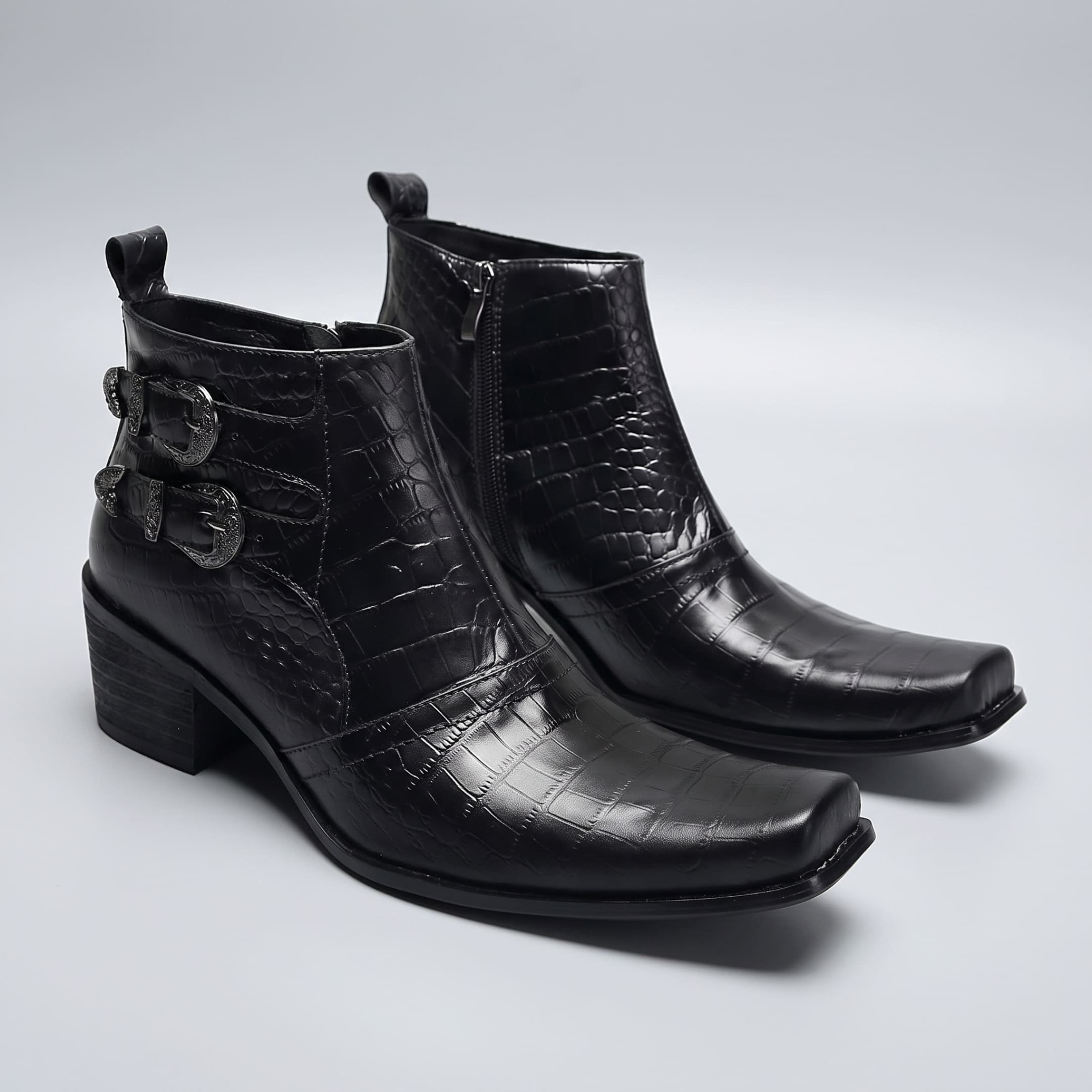 FORCIANO SCAROSSO black genuine leather height increasing boots displayed as a pair in front three-quarter view with textured uppers, buckles and side zipper.