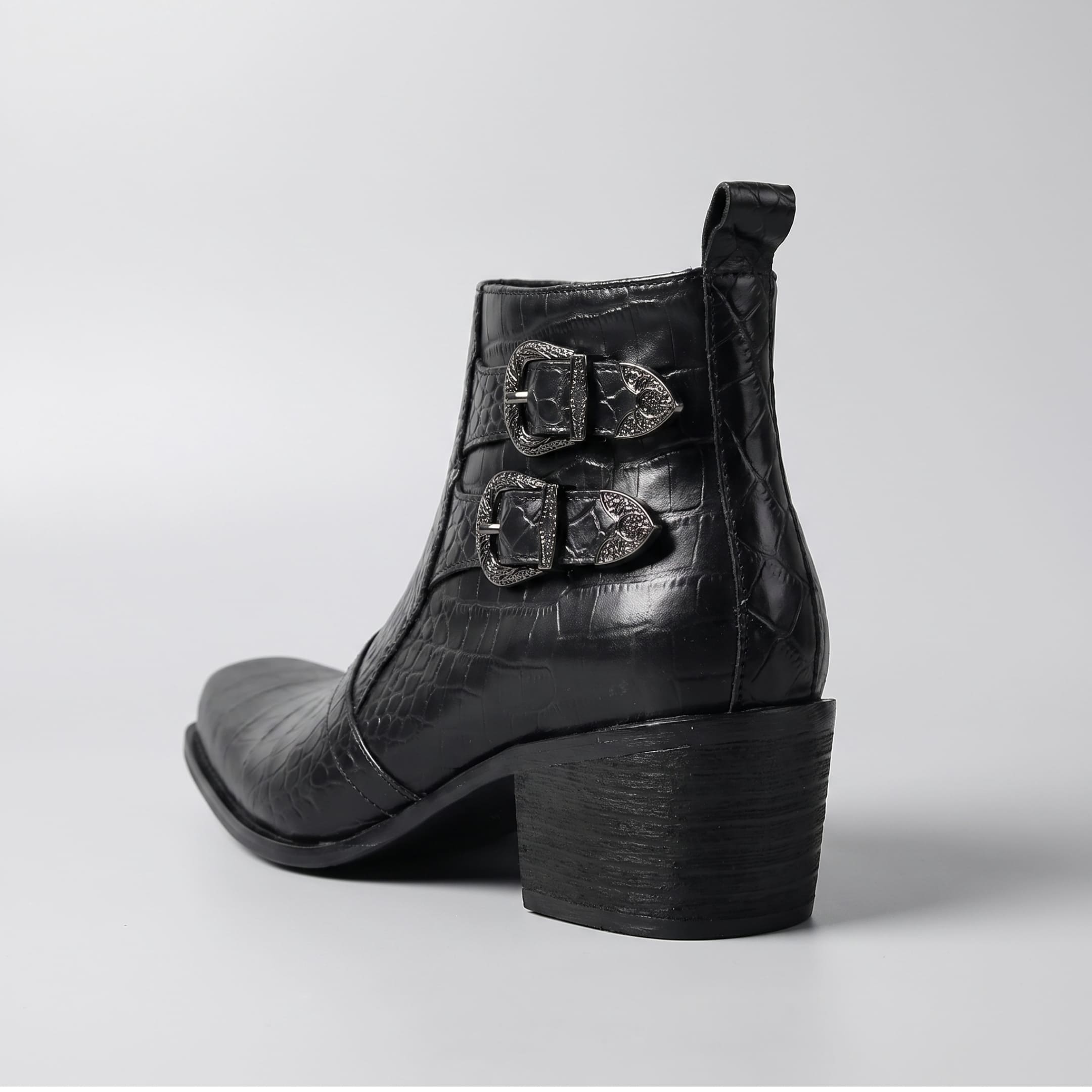FORCIANO SCAROSSO black genuine leather height increasing boot shown from the rear three-quarter angle with double buckles, textured upper and block heel.