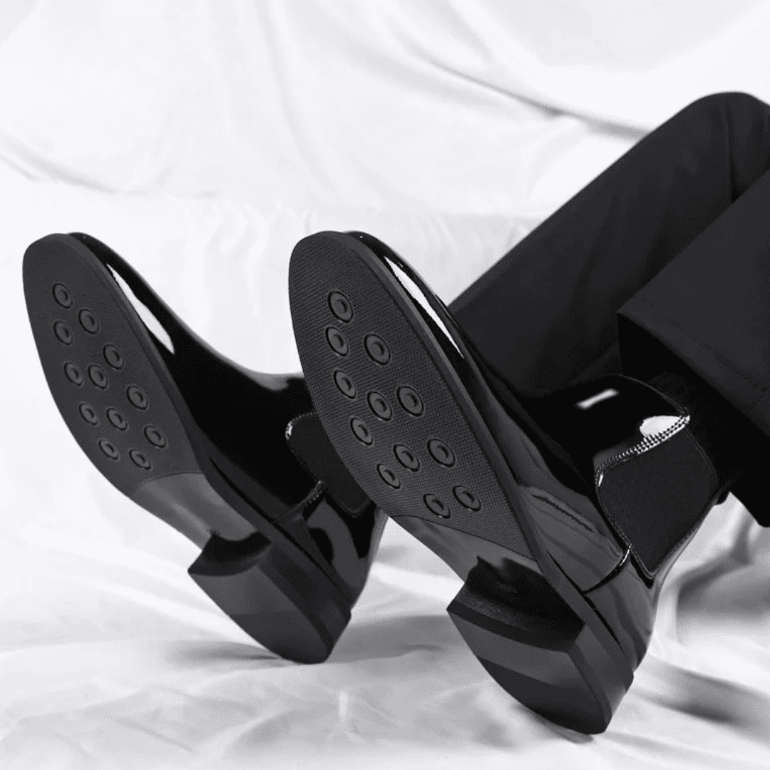 FORCIANO SILVAN black Chelsea Height Increasing Boots shown worn with both outsoles facing the camera, revealing the circular tread pattern.